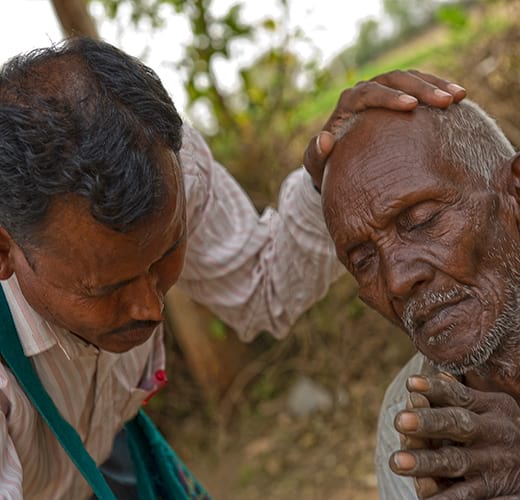 National missionary worker praying for a man