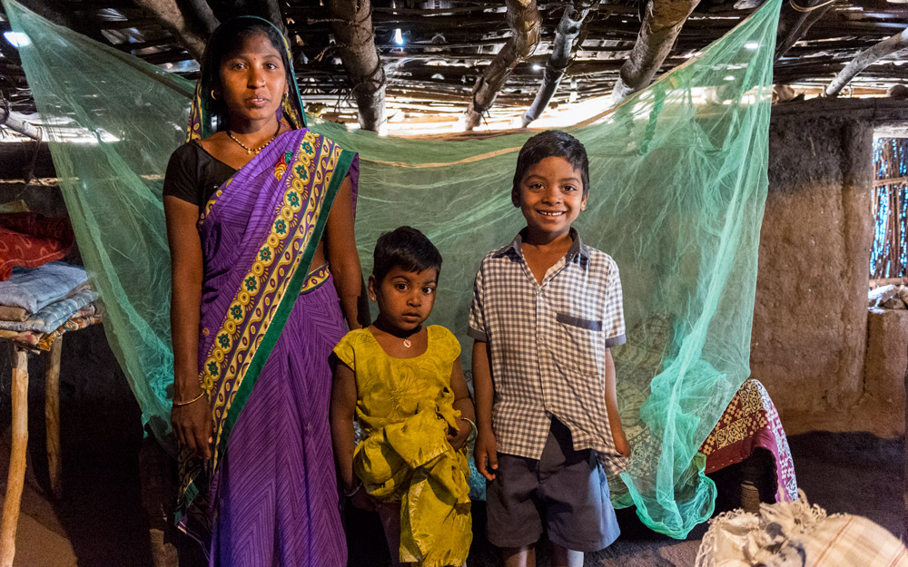 A family in front of their mosquito net