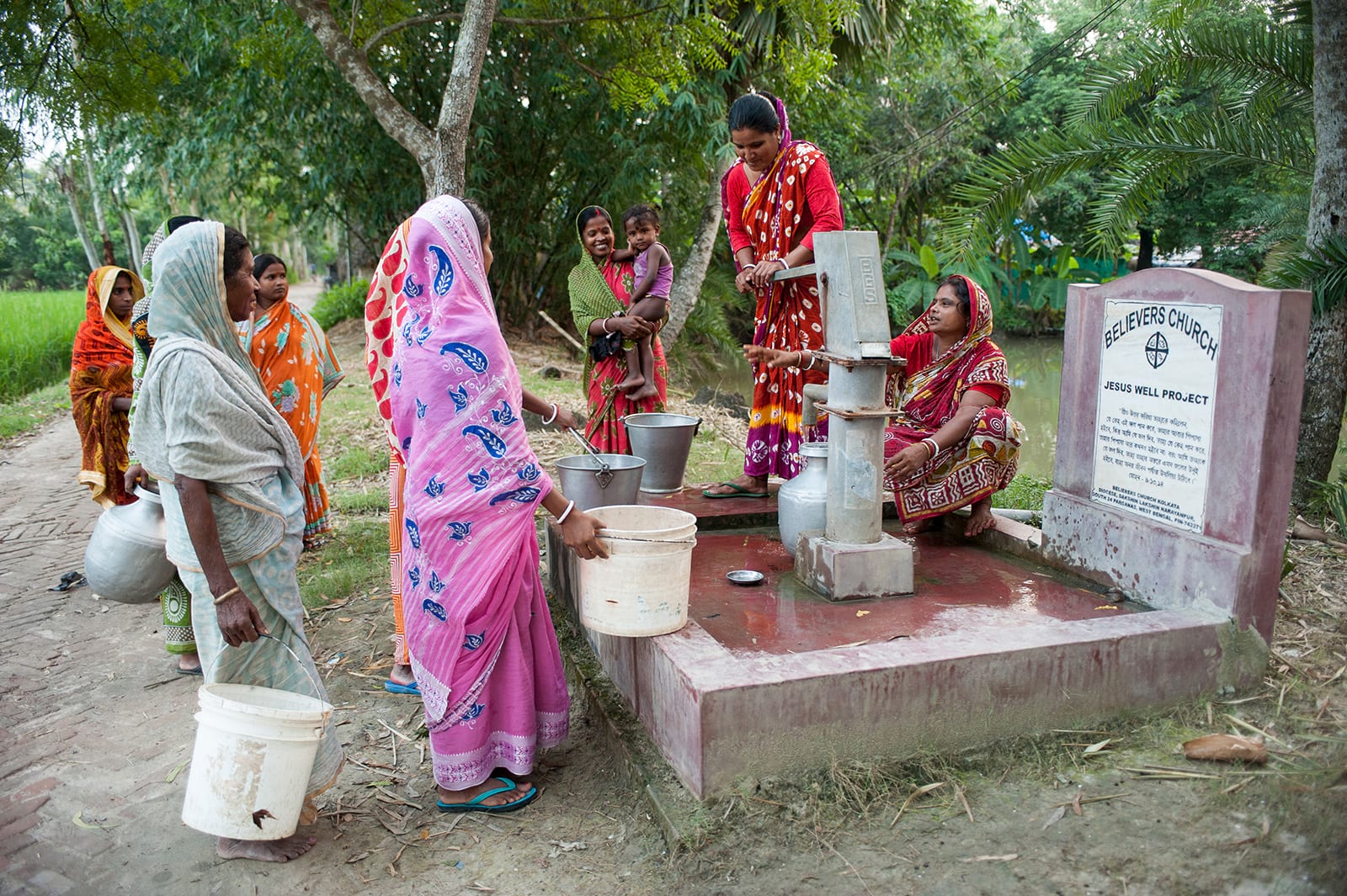 Groupe de femmes tirant de l’eau propre d’un Puits de Jésus.